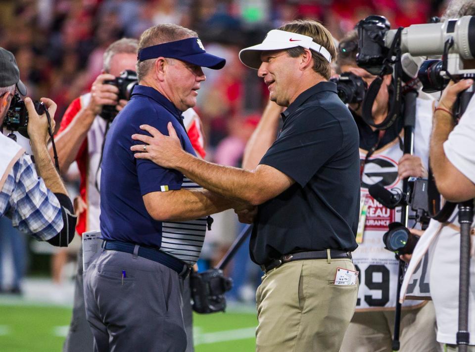 Notre Dame head coach Brian Kelly, left, is greeted at midfield by Georgia head coach Kirby Smart before the Notre Dame-Georgia NCAA college football game on Saturday, Sept. 21, 2019, inside Sanford Stadium in Athens, Ga.
