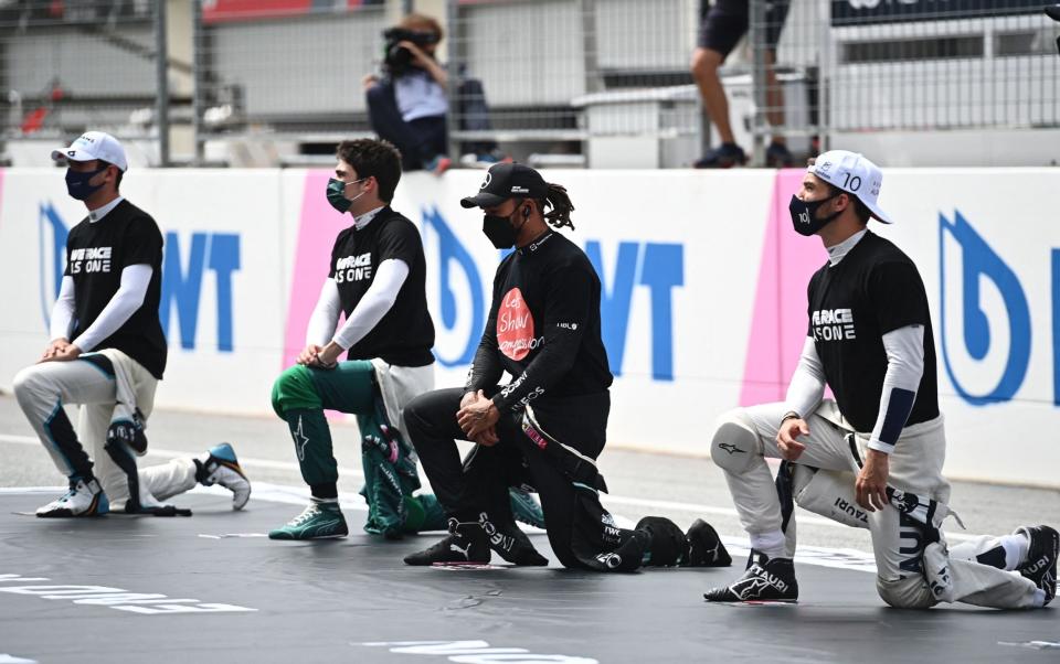 Williams' Canadian driver Nicholas Latifi, Aston Martin's Canadian driver Lance Stroll, Mercedes' British driver Lewis Hamilton and AlphaTauri's French driver Pierre Gasly take a knee in support of the Black Lives Matter campaign against rasicm prior the Formula One Austrian Grand Prix at the Red Bull Ring race track in Spielberg, Austria, on July 4, 2021. - GETTY IMAGES