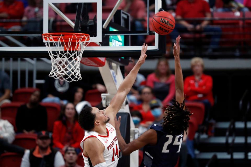 Texas Tech's Marcus Santos-Silva (14) tries to block the shot by North Florida's Jadyn Parker (24) during the first half of an NCAA college basketball game Tuesday, Nov. 9, 2021, in Lubbock, Texas. (Brad Tollefson/Lubbock Avalanche-Journal via AP)