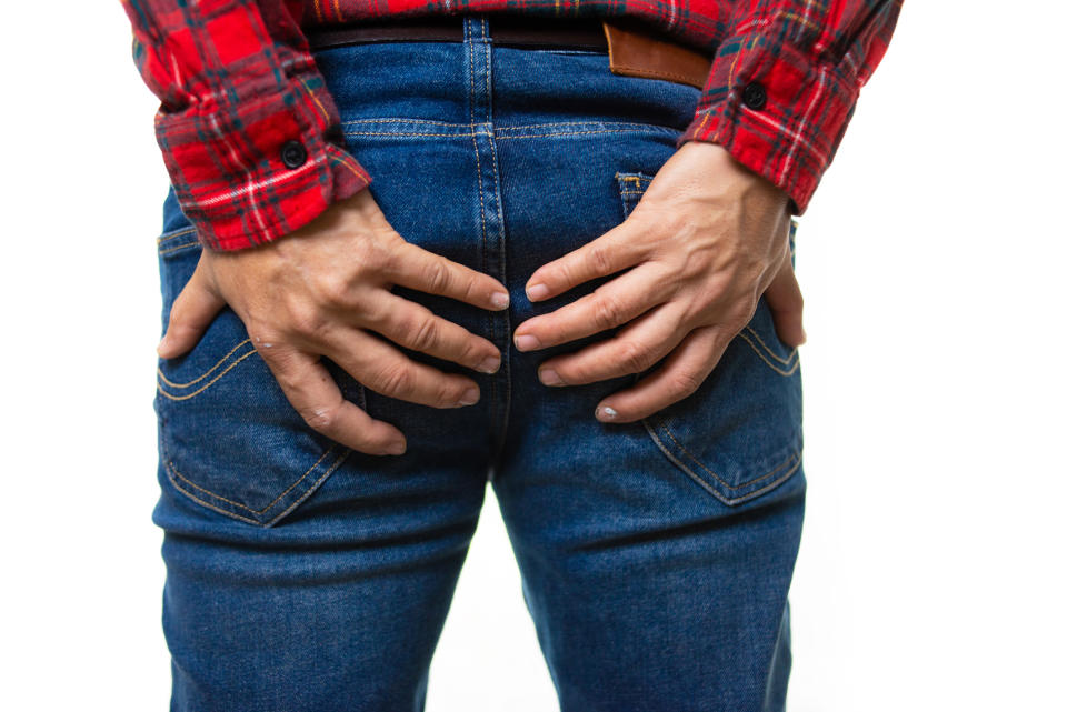 Close-up of a jeans-covered rear end with hands cupping the cheeks