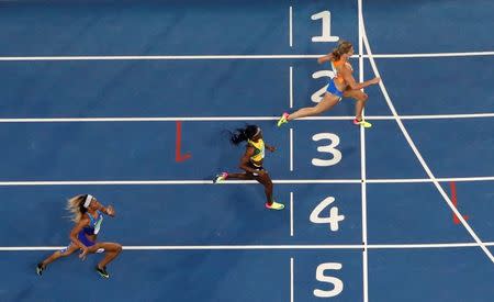 2016 Rio Olympics Athletics - Semifinal - Women's 200m Semifinals - Olympic Stadium - Rio de Janeiro, Brazil - 16/08/2016. Dafne Schippers (NED) of Netherlands crosses the finish line ahead of Elaine Thompson (JAM) of Jamaica and Deajah Stevens (USA) of USA. REUTERS/Fabrizio Bensch