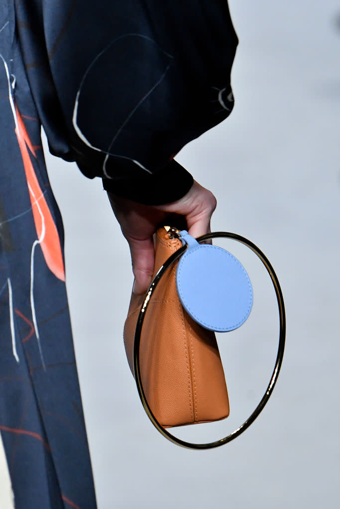 <p>A model carries a small brown clutch with a metal hoop at the Roksanda FW18 show. (Photo: Getty Images) </p>