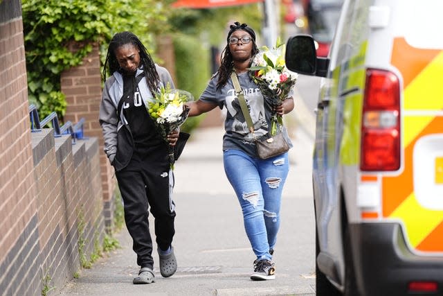 Members of the public arrive to lay floral tributes on Overbury Street, near the scene in Rushmore Road, Clapton, east London