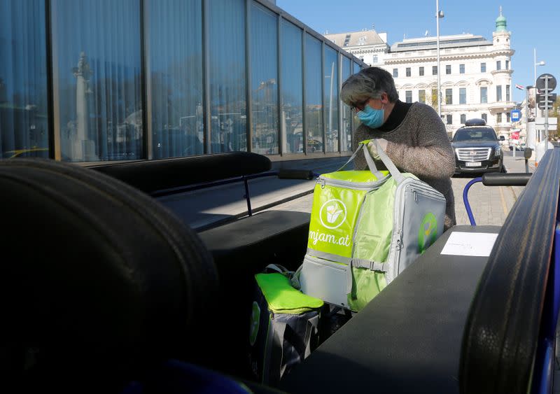 A coachwoman loads food packages on a Fiaker horse carriage in Vienna