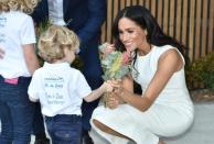 Strike a posie: Meghan has been presented with gifts at every turn from people young and old