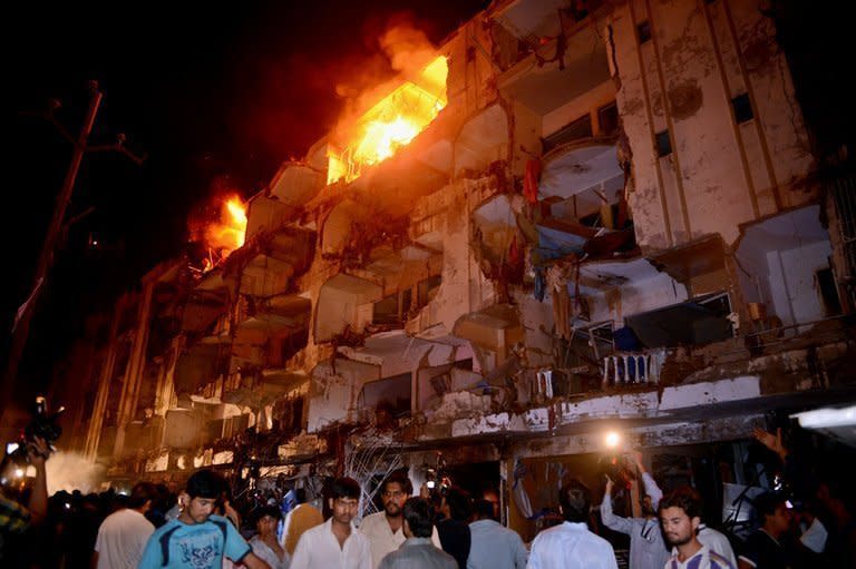 People gather at the site of a bomb blast in Karachi, Pakistan on March 3, 2013. Thousands of Pakistanis have attended funerals for victims of a bombing that killed 48 people in a Shiite Muslim area of Karachi, the latest in a series of devastating attacks ahead of elections