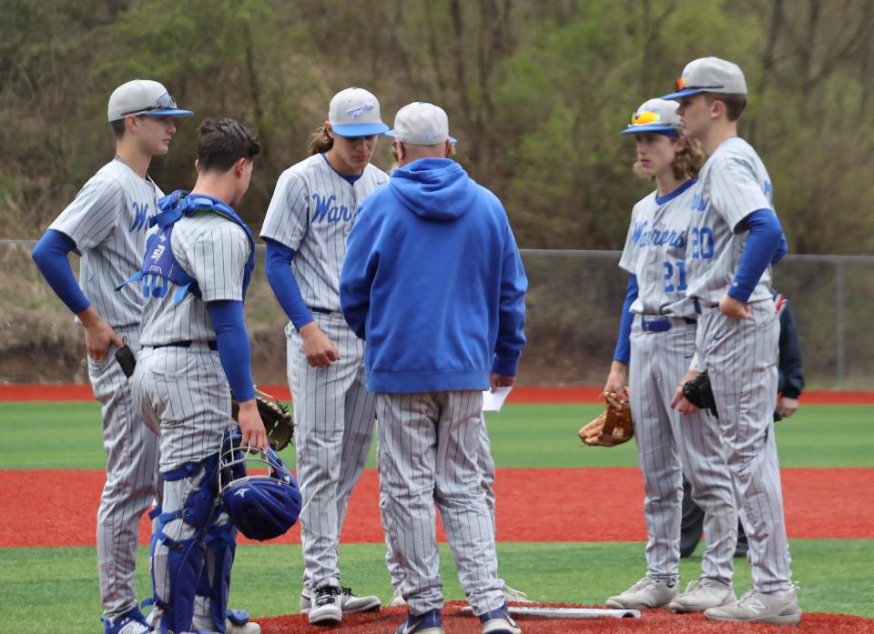 Buckeye Trail head coach Cory McQuain discusses strategy with Braden Williams and other Warrior players on the mound during a recent baseball game at Buckeye Trail High School. Buckeye Trail is seeking to capture its third consecutive Inter-Valley Conference baseball title this season.