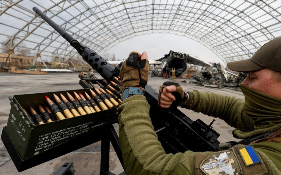 A member of the mobile air defence group checks an M2 Browning machine gun atop a pick-up truck donated by volunteers, in Kyiv region - REUTERS/Valentyn Ogirenko