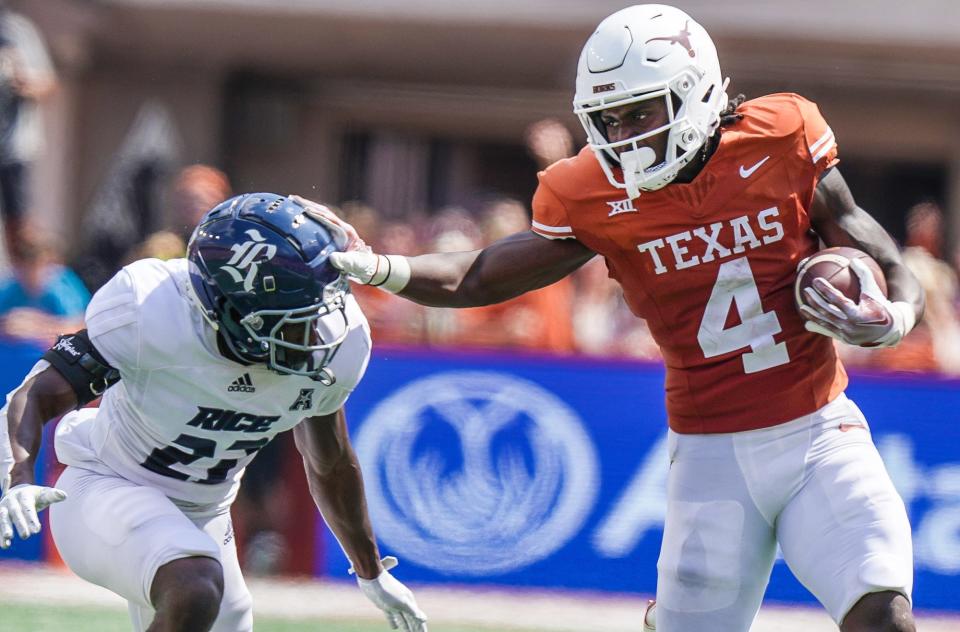 Texas Longhorns running back CJ Baxter Jr. (4) fights for yardage Rice Owls cornerback Jamarion Clark (21) in the second quarter of an NCAA college football game, Saturday, Sept. 2, 2023, in Austin, Texas.