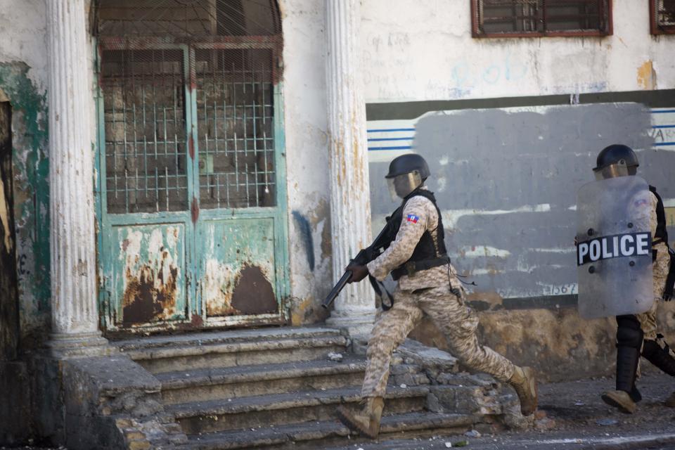 Police officers run after demonstrators during a protest to demand the resignation of President Jovenel Moise and demanding to know how Petro Caribe funds have been used by the current and past administrations, in Port-au-Prince, Haiti, Saturday, Feb. 9, 2019. Much of the financial support to help Haiti rebuild after the 2010 earthquake comes from Venezuela's Petro Caribe fund, a 2005 pact that gives suppliers below-market financing for oil and is under the control of the central government. (AP Photo/Dieu Nalio Chery)