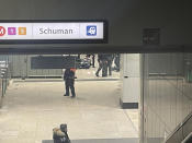 Police surround a man who sits on the floor of a metro station near EU headquarters in Brussels, Monday, Jan. 30, 2023. News reports on Monday said that one man was injured in a knife incident around the European Union's headquarters in Brussels before one suspect was detained. (Jack Parrock via AP)