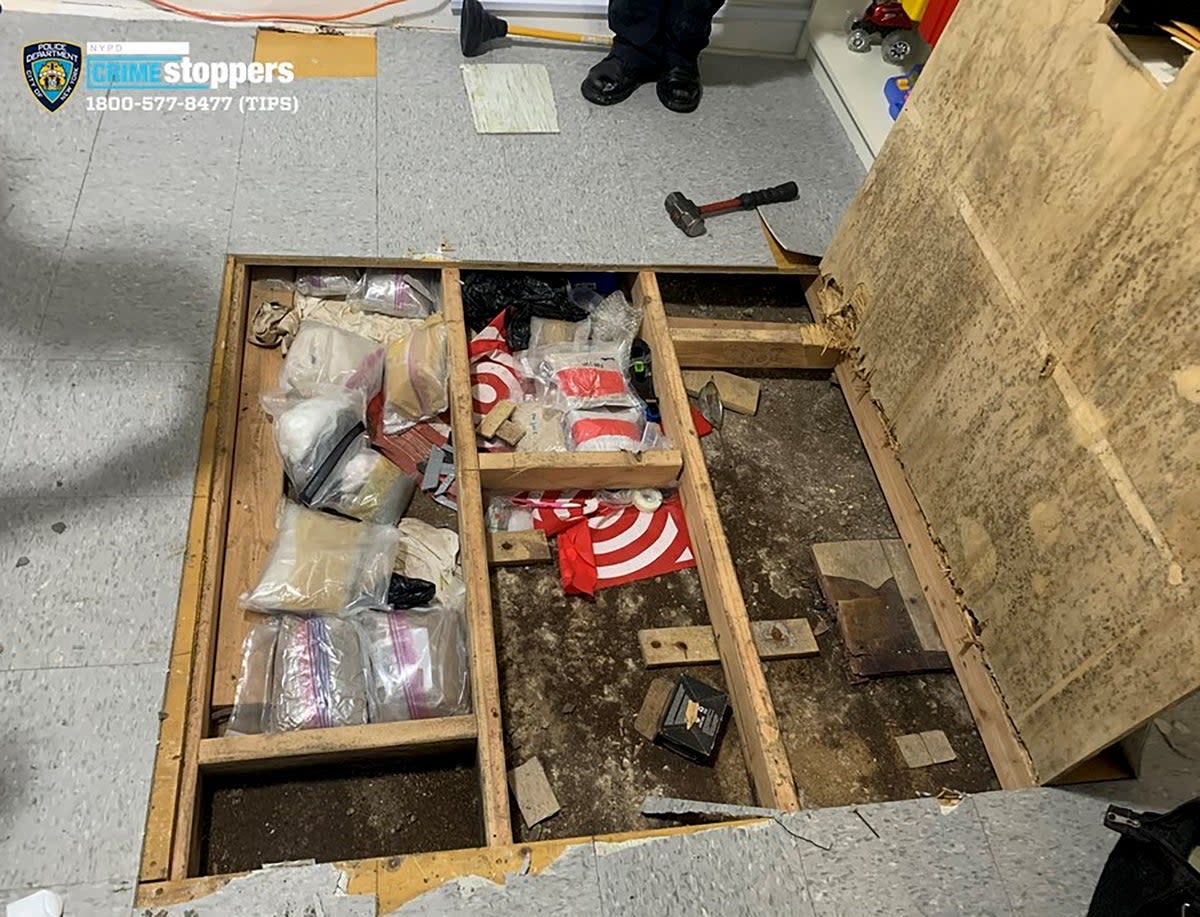 A trap door leans open over narcotics, including fentanyl, and drug paraphernalia stored in the floor of a day care centre (AP)