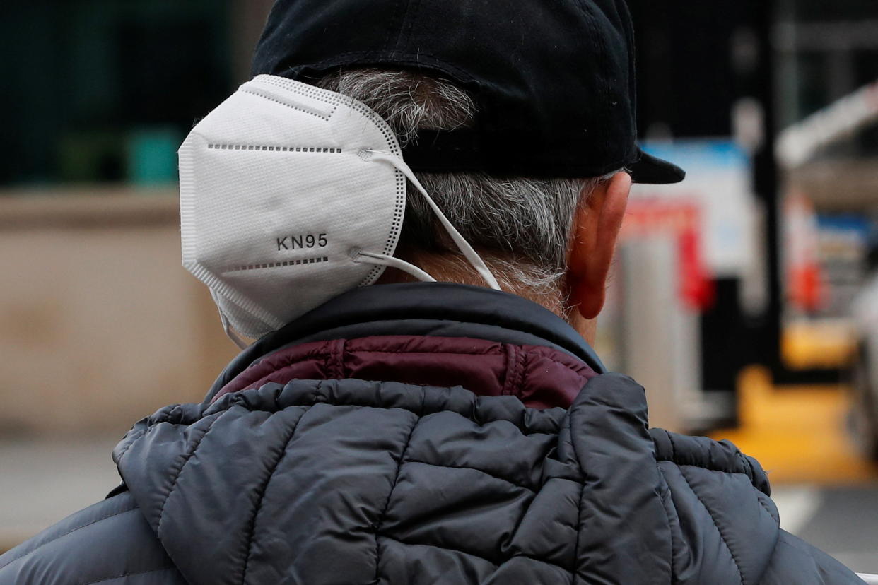 A man wears a mask on his neck as he walks along a Manhattan street last month.