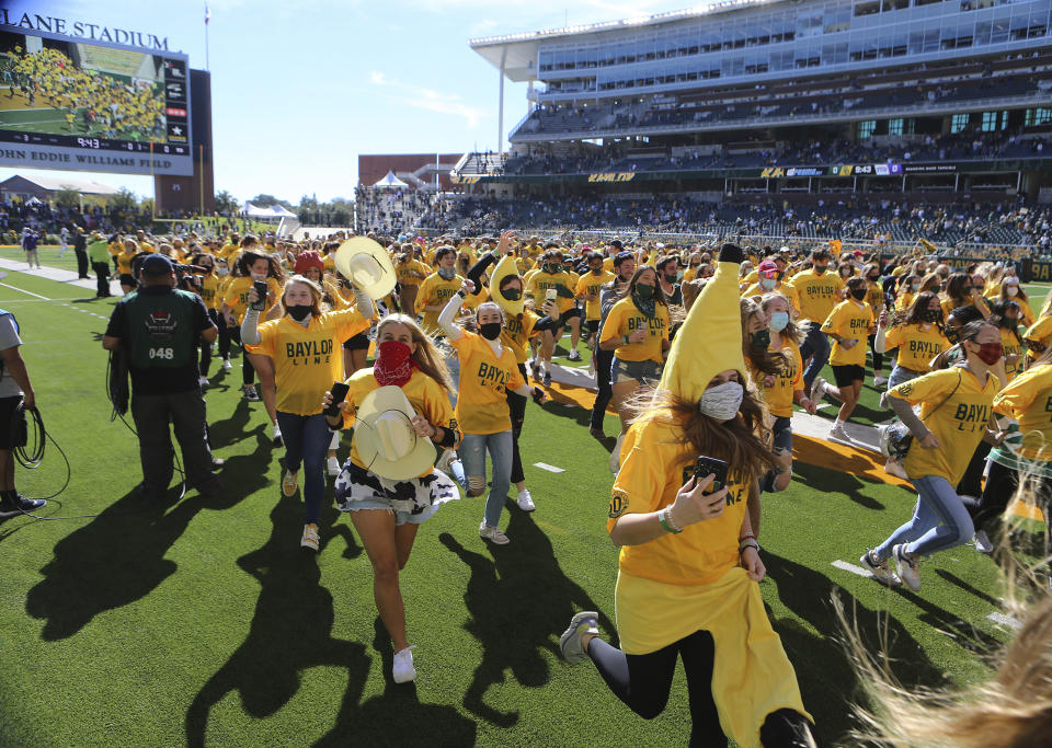 The Baylor Line students run onto the field before Baylor's NCAA college football game against TCU in Waco, Texas, Saturday, Oct. 31, 2020. (Jerry Larson/Waco Tribune-Herald via AP)