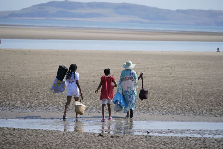 La gente camina en la playa de Malahide, cerca de Dublín, Irlanda, el lunes 18 de julio de 2022.