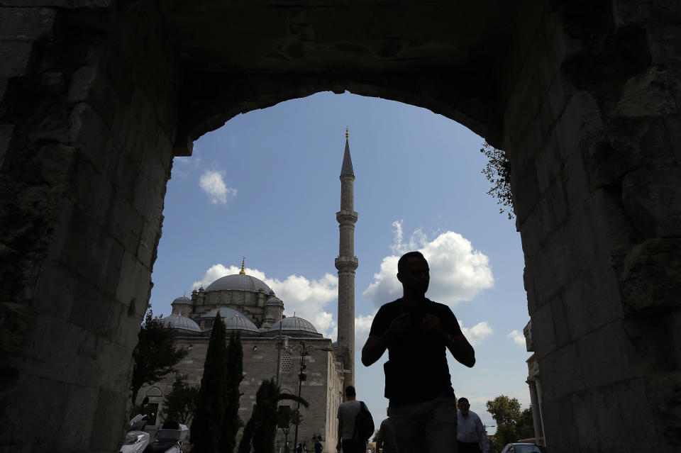 In this photo taken on Tuesday, Aug. 20, 2019, a man walks near Fatih mosque in Istanbul. Syrians say Turkey has been detaining and forcing some Syrian refugees to return back to their country the past month. The expulsions reflect increasing anti-refugee sentiment in Turkey, which opened its doors to millions of Syrians fleeing their country's civil war. (AP Photo/Lefteris Pitarakis)