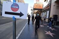 People walk on Hollywood Boulevard outside the Pantages Theater polling station, during the global outbreak of the coronavirus disease (COVID-19), in Hollywood, Los Angeles