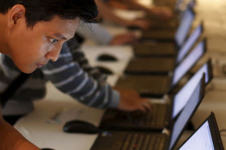 An Indonesian youth fills up job application forms on laptops provided by organizers at Indonesia Techno Career in Jakarta, June 11, 2015. REUTERS/Beawiharta