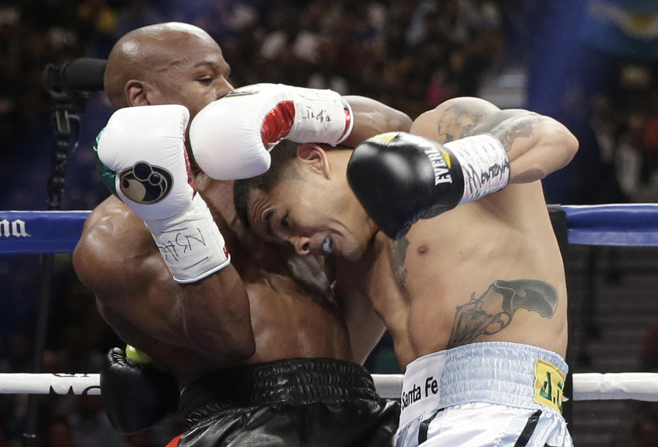 Floyd Mayweather Jr., left, trades blows with Marcos Maidana, from Argentina, in their WBC-WBA welterweight title boxing fight Saturday, May 3, 2014, in Las Vegas. (AP Photo/Isaac Brekken)