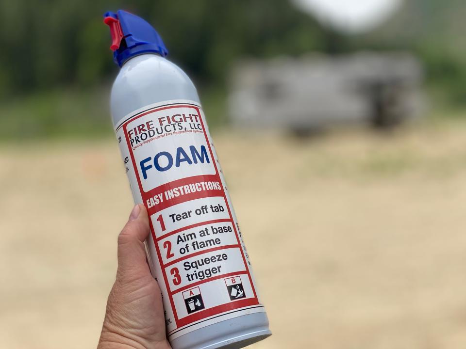 A hand holds a fire fight foam can