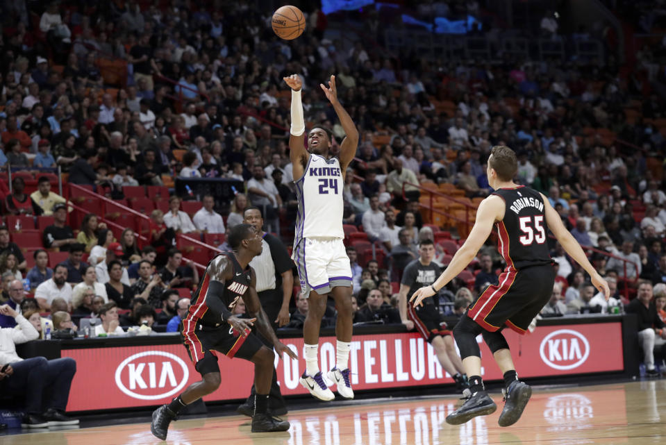 Sacramento Kings guard Buddy Hield (24) attempts a 3-pointer over Miami Heat guard Kendrick Nunn, left, and forward Duncan Robinson (55) during the first half of an NBA basketball game, Monday, Jan. 20, 2020, in Miami. (AP Photo/Lynne Sladky)