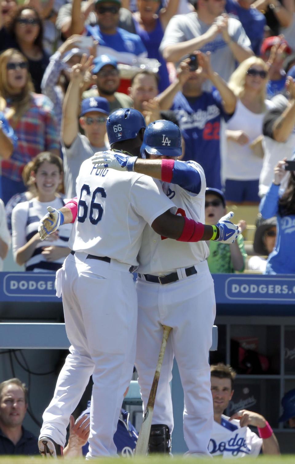 Los Angeles Dodgers’ Yasiel Puig (66) gets a hug from Adrian Gonzalez after Puig hit a solo home run against the San Francisco Giants in the sixth inning of a baseball game on Sunday, May 11, 2014, in Los Angeles. (AP Photo/Alex Gallardo)