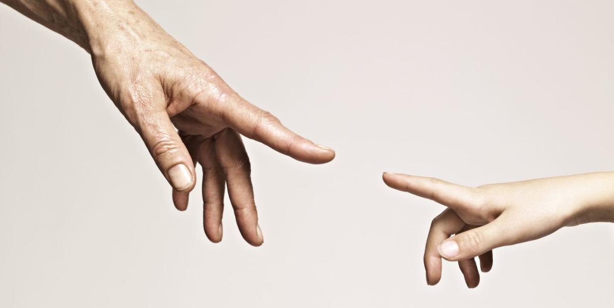 young and old hands point together