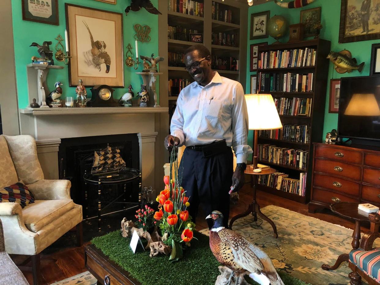 Wayne Crocker, Director of Library Services of Petersburg Public Library admires a flower arrangement by Petersburg Garden Club member Bettie Guthrie at the home of Michael Levin Maszaros and Andrew Cushin on April 26, 2022.