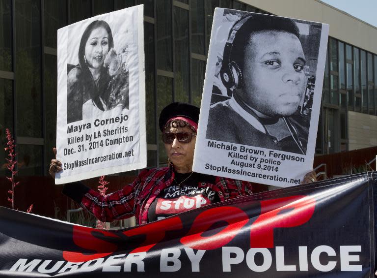 Activists hold up images of police shooting victims during a protest outside LAPD headquarters in Los Angeles, California on April 9, 2015 against the recent shooting death of Walter Scott in North Charleston by a police officer