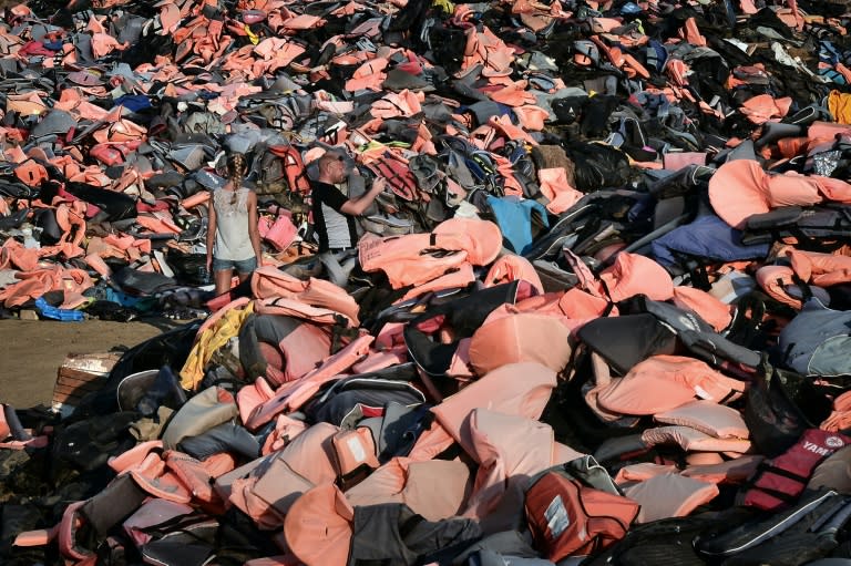 Norwegian tourists photograph the dump above the village of Molyvos on the island of Lesbos filled with thousands of lifejackets, evidence of last year's refugee crisis