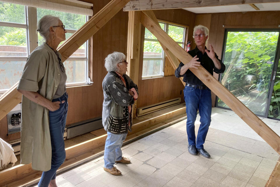 Sarah Griswold, left, Davyne Verstandig, center, and Marc Olivieri, members of the Arthur Miller Writing Studio board, check on the condition of the former studio of the late American playwright in Roxbury, Conn., Wednesday, June 21, 2023. The studio has been stored for the past five years behind the Roxbury Town Hall, on property used by the town's public works department. The group, along with Miller's daughter Rebecca Miller, hope to raise $1 million to restore the modest structure, relocate it to a nearby local library and create programming that will inspire other writers. (AP Photo/Susan Haigh)