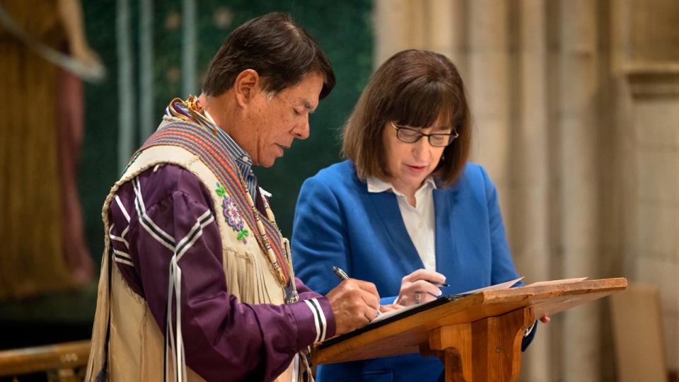 Ray Halbritter, left, representing the Oneida Indian Nation, and Cornell University President Martha E. Pollack, sign documents that repatriate ancestral remains from the university to the Oneida Indian Nation Tuesday, February 21, 2023. 