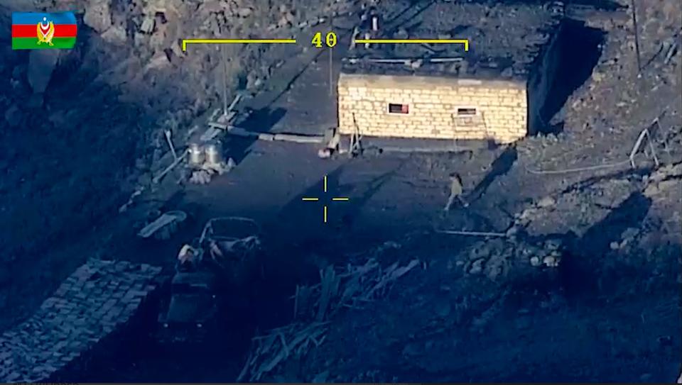 In this photo taken from a drone video released by Defense Ministry of Azerbaijan on Sept. 20, 2023, men walk at an area which Azerbaijan says hosts Armenian forces' positions in the breakaway territory of Nagorno-Karabakh.