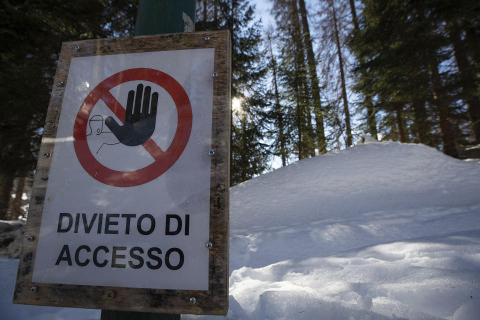 A No Entry sign is seen by the bobsled track in Cortina d'Ampezzo, Italy, Wednesday, Feb. 17, 2021. Bobsledding tradition in Cortina goes back nearly a century and locals are hoping that the Eugenio Monti track can be reopened for the 2026 Olympics in the Italian resort. (AP Photo/Gabriele Facciotti)