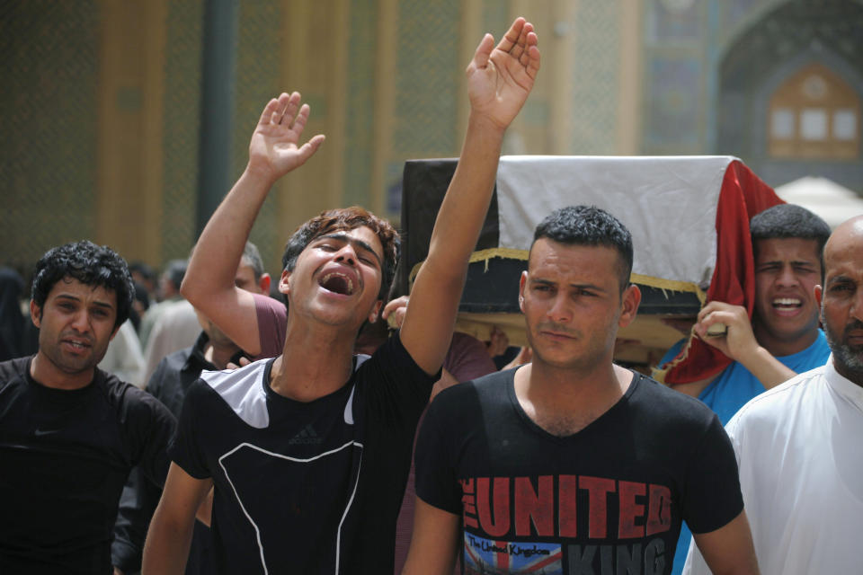 Friends of Mustafa Mounir, 19, chant slogans against the al-Qaida breakaway group Islamic State of Iraq and the Levant (ISIL), while carrying his flag-draped coffin during his funeral procession in Najaf, 100 miles (160 kilometers) south of Baghdad, Iraq, Friday, April 18, 2014. Mustafa Mounir was killed in a car bomb attack in Baghdad on Thursday, his family said. (AP Photo/Jaber al-Helo)
