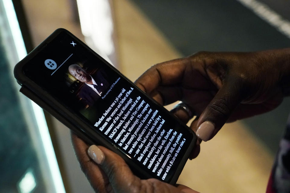 Pamela D.C. Junior, director of the Two Mississippi Museums in Jackson, listens as she reads the cold case selection of Wharlest Jackson, a local NAACP leader who was killed in 1967 by a car bomb, from the PBS Frontline's traveling augmented-reality exhibit, "Un(re)solved" in the museum's special exhibit room, Friday, Aug. 27, 2021. The exhibit opened Saturday, Aug. 28, to align with the commemoration of the death of Emmett Till, a Chicago teenager who was lynched in Mississippi in 1955. The multi-media platform examines the federal government's efforts to investigate more than 150 civil rights era cold cases on the Emmett Till Unsolved Civil Rights Crime Act. (AP Photo/Rogelio V. Solis)