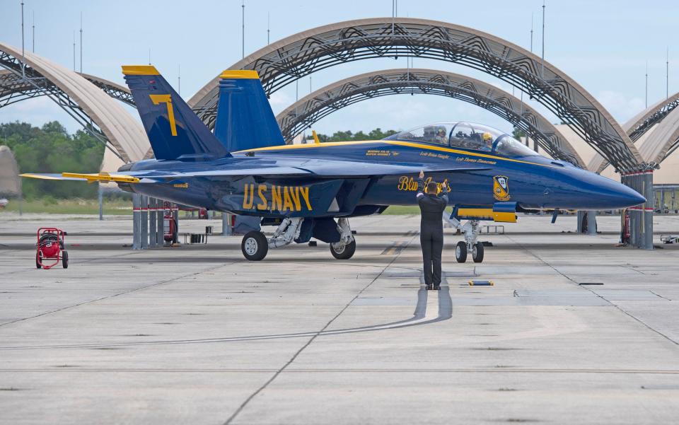 A Blue Angel ground crew member directs one of the team's A/F-18 Super Hornets at Sherman Field at Naval Air Station Pensacola on Thursday, July 6, 2023.