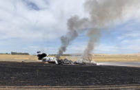 In this photo provided by the California Highway Patrol is the scene where a jet burst into flames after aborting a takeoff Wednesday, Aug. 21, 2019, in Oroville, Calif. Officials say a small jet burst into flames while trying to take off from a small Northern California airport, but all 10 people on board escaped injury. The Federal Aviation Administration says the pilot of the twin-engine Cessna Citation jet aborted its takeoff at Oroville Municipal Airport for unknown reasons shortly before noon Wednesday. The aircraft slid off the end of the runway into the grass and caught fire. The plane was flying from Oroville to Portland International Airport in Oregon. (California Highway Patrol via AP)