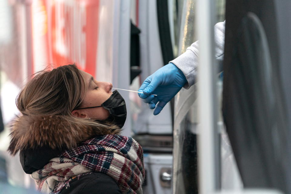 A woman takes a coronavirus disease (COVID-19) test at a pop-up testing site in New York City, U.S., December 16, 2021. REUTERS/Jeenah Moon