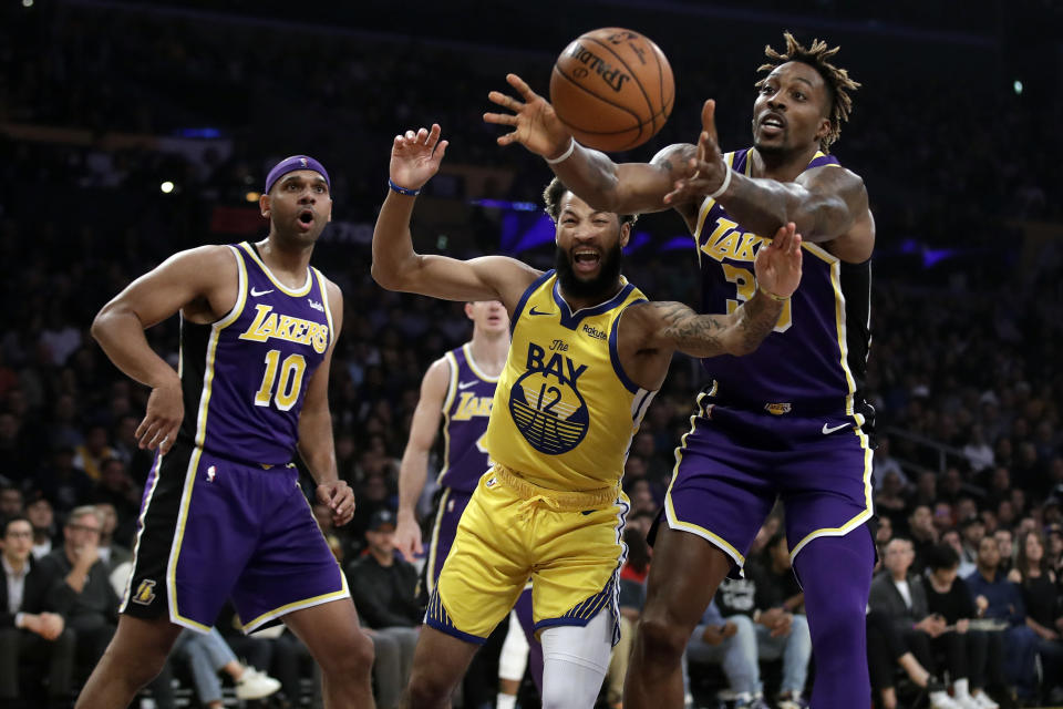 Los Angeles Lakers' Dwight Howard, right, grabs a rebound over Golden State Warriors' Ky Bowman (12) during the first half of an NBA basketball game Wednesday, Nov. 13, 2019, in Los Angeles. (AP Photo/Marcio Jose Sanchez)