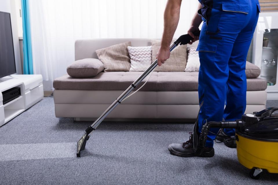 Janitor's Hand Cleaning Carpet With Vacuum Cleaner