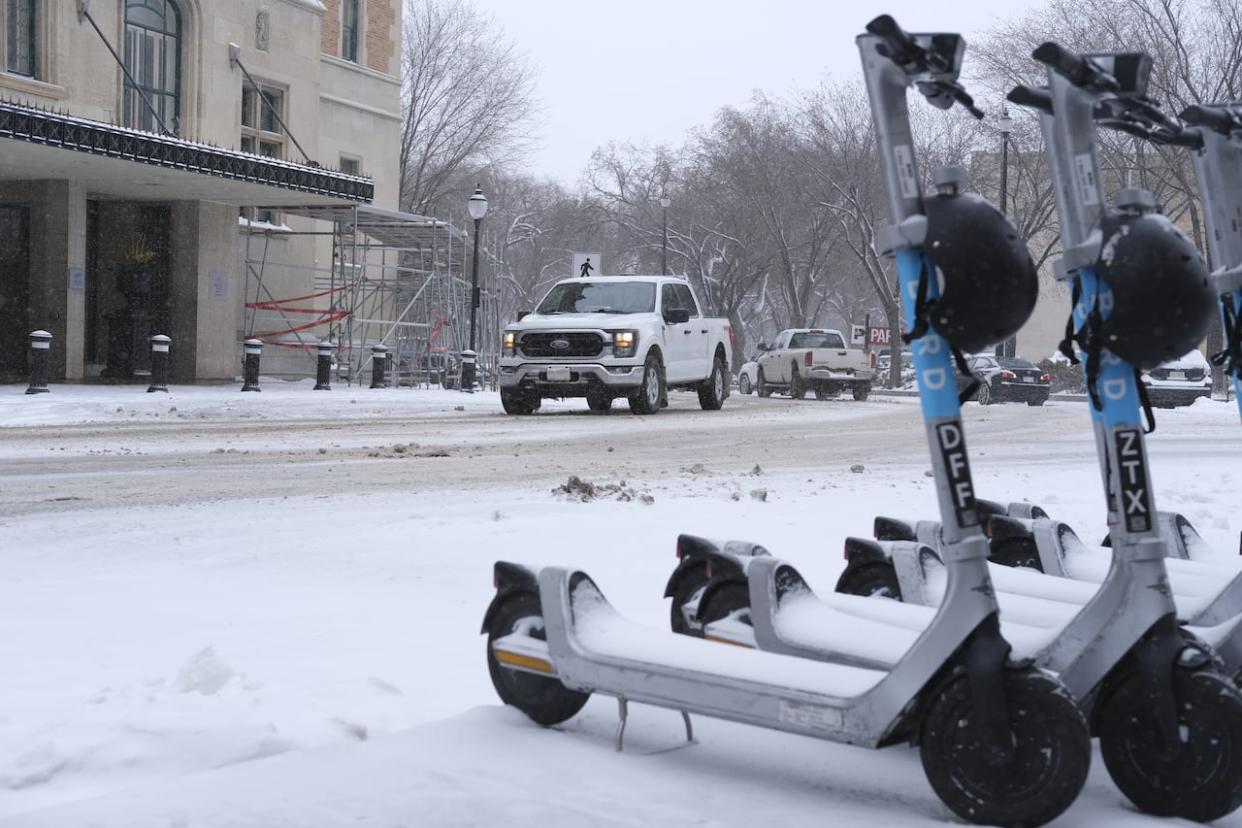 E-scooters and downtown Saskatoon are blanketed with another dump of snow. Light but steady snowfall continued to sprinkle most of central and southern Saskatchewan Thursday. (Liam O'Connor/CBC - image credit)