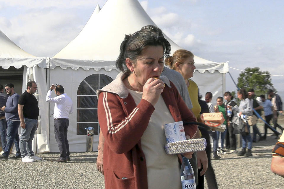 In this image taken from video, a refugee from the first group of about 30 people from Nagorno-Karabakh eat after arriving to Armenia's Kornidzor village in Syunik region, Armenia, Sunday, Sept. 24, 2023. The first refugees from Nagorno-Karabakh have arrived in Armenia, local officials reported Sunday, and more were expected to come after a 10-month blockade and a lightning military offensive this month that resulted in Azerbaijan reclaiming full control of the breakaway region. (AP Photo)