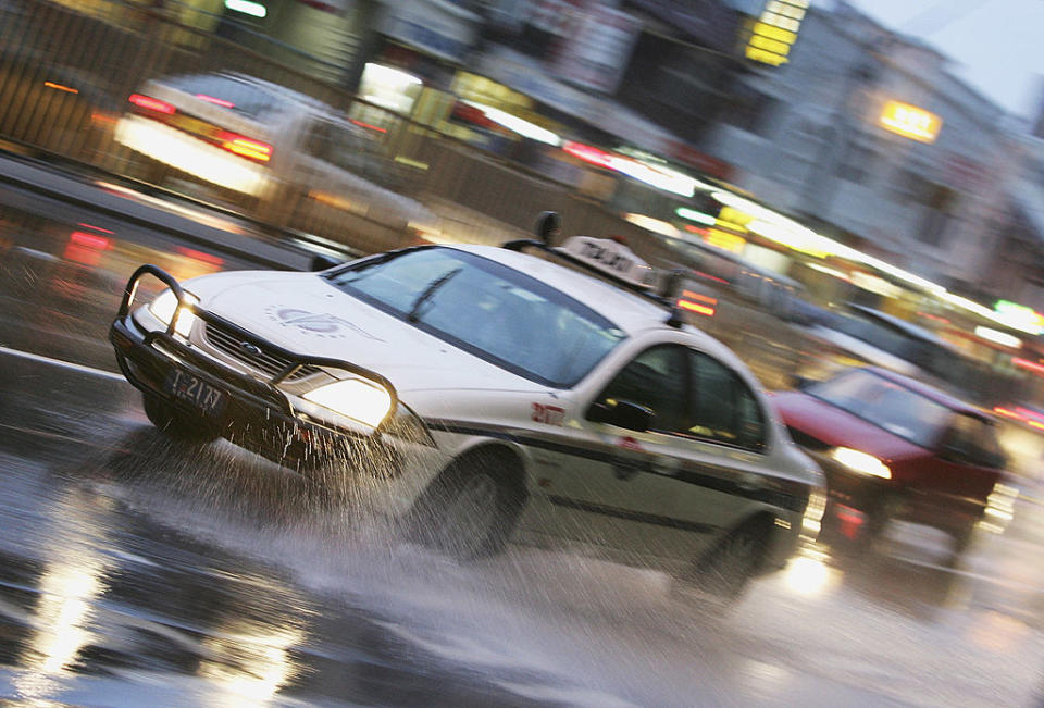 SYDNEY, NSW – JUNE 30: A taxi wades through water flooding the Pacific Highway as heavy rain continues to fall across Sydney June 30, 2005 in Sydney, Australia. (Photo by Cameron Spencer/Getty Images)