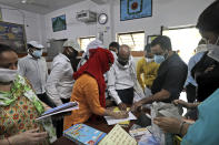 Indian government school teachers check their names after they were assigned to conduct survey in residential areas of New Delhi, India, Saturday, June 27, 2020. A massive survey to take down health details of New Delhi's entire population of 28 millions and test everyone with symptoms for COVID-19 started Saturday. Teams comprising of health workers and other government officials, including teachers went from home to home to conduct the survey, that is trying to screen everyone by July 6, as Delhi has become the worst hit city in India. (AP Photo/Manish Swarup)