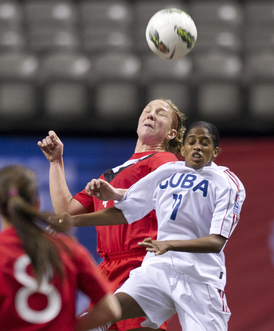 VANCOUVER, CANADA - JANUARY 21: Rachel Pelaez #11 of Cuba battles for the loose ball with Carmelina Moscato #4 of Canada during the second half of the 2012 CONCACAF Women's Olympic Qualifying Tournament at BC Place on January 21, 2012 in Vancouver, British Columbia, Canada. (Photo by Rich Lam/Getty Images)