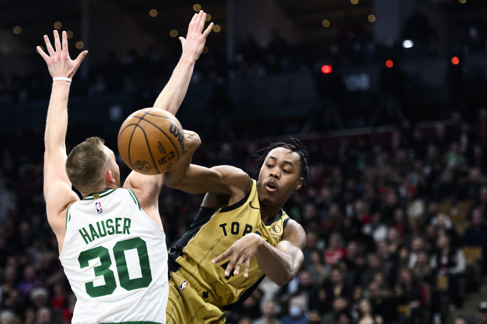 Toronto Raptors forward Scottie Barnes (4) passes the ball around Boston Celtics forward Sam Hauser (30) during the first half of an NBA basketball game Friday, Nov. 17, 2023, in Toronto. (Christopher Katsarov/The Canadian Press via AP)