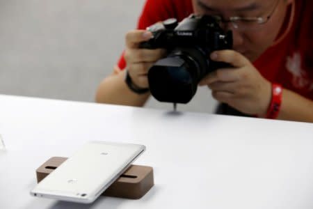 FILE PHOTO: A journalist takes picture of Xiaomi's new mobile phone Mi Max at its launch in Beijing, May 10, 2016. REUTERS/Kim Kyung-Hoon/File Photo