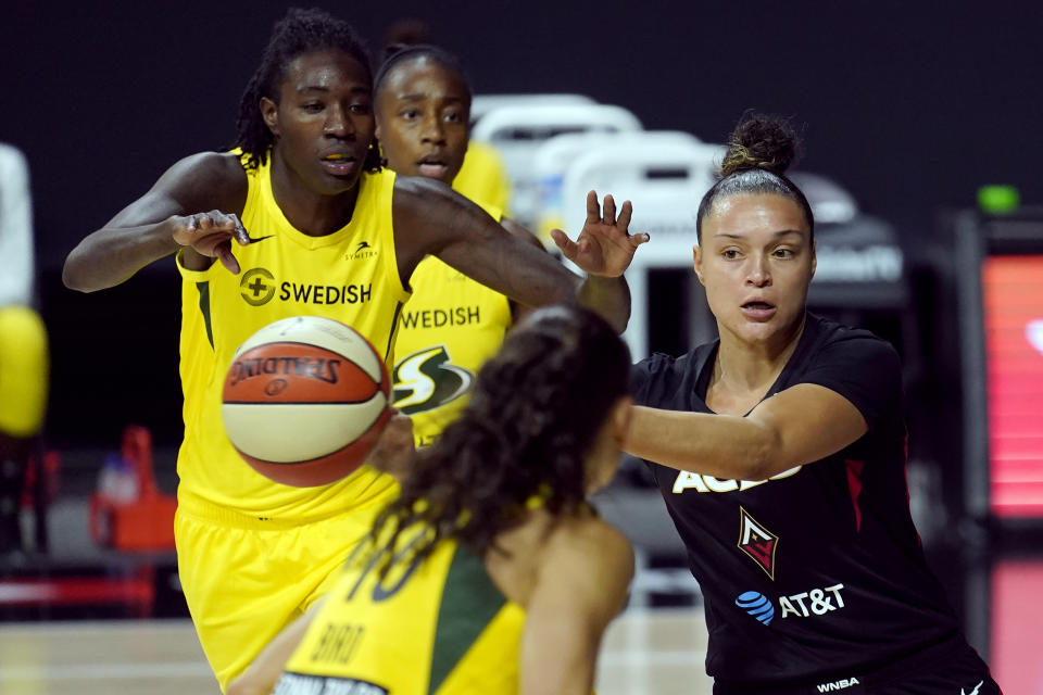 Las Vegas Aces guard Kayla McBride passes the ball after getting around Seattle Storm forward Natasha Howard (6) during the first half of Game 1 of basketball's WNBA Finals Friday, Oct. 2, 2020, in Bradenton, Fla. (AP Photo/Chris O'Meara)