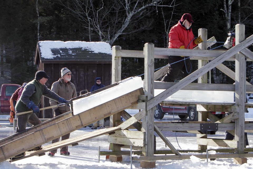 Blocks of ice are loaded onto a platform in Squaw Cove on Squam Lake in Sandwich, N.H. Thursday Jan. 9, 2014. Thousands of blocks of ice are taken from the frozen lake and stored in an ice house for use in the summer for residents at the Rockywold-Deephaven Camps. (AP Photo/Jim Cole)